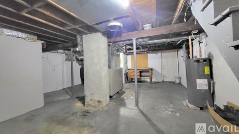 A spacious basement with concrete floors and exposed pipes.