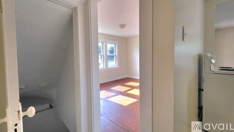 A room with a white door and a window with a view of a building outside.