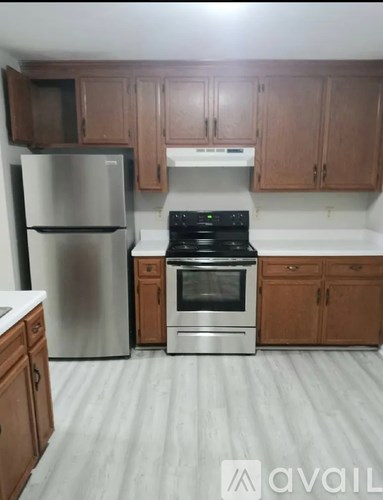 A kitchen with a stainless steel refrigerator, oven, and cabinets.