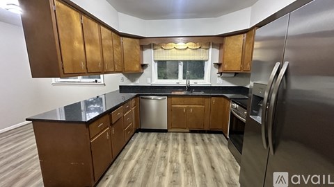 A kitchen with wooden cabinets and a black countertop.
