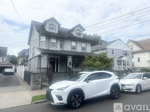Two white cars parked in front of a house.