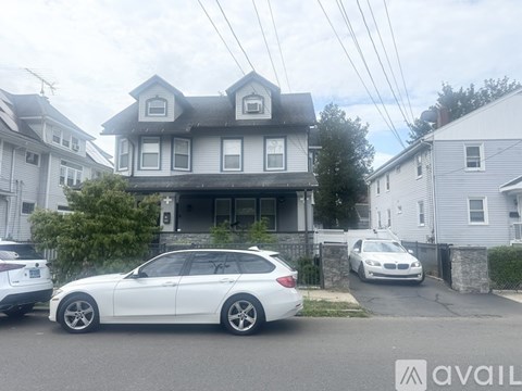 A white car is parked in front of a house.