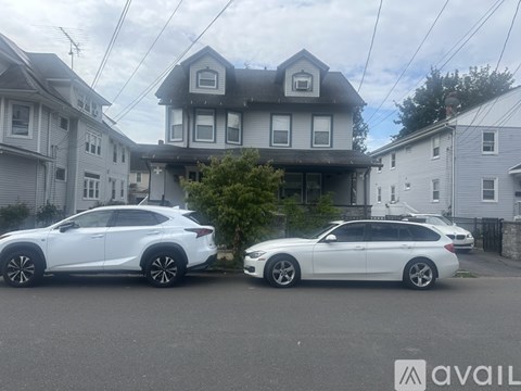 Two white cars parked in front of a house.