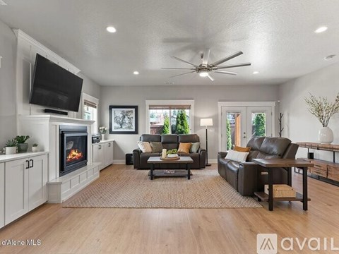 A living room with a fireplace and a television on the wall.