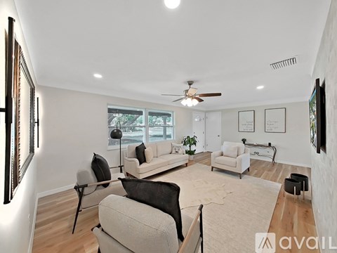 A living room with a white couch and a black chair.