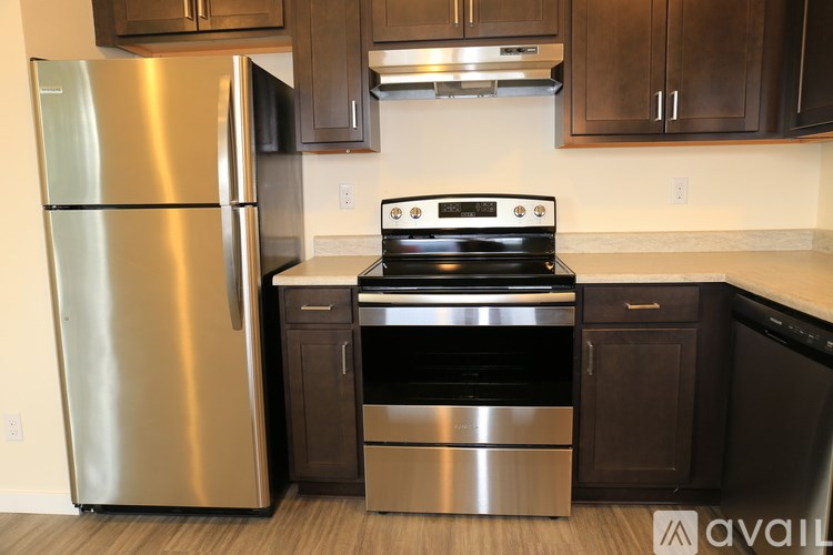A kitchen with a stainless steel refrigerator, stove, and oven.