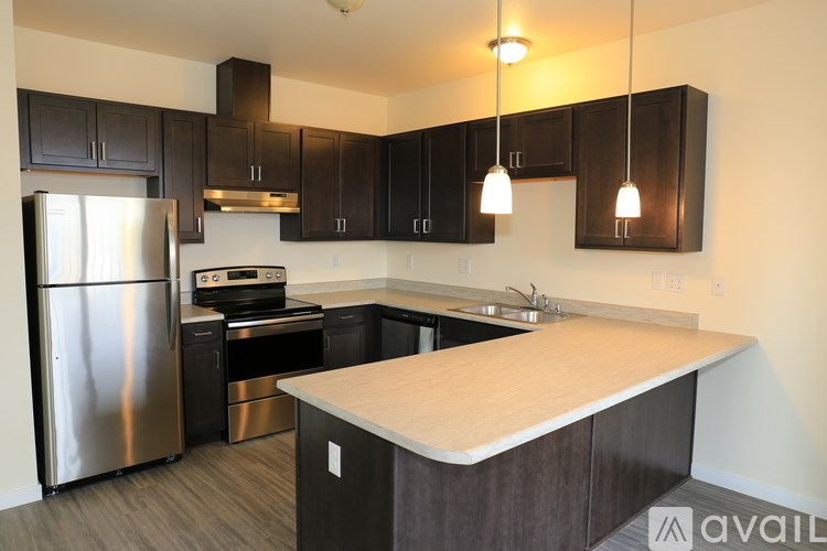 A kitchen with a refrigerator, oven, and sink.