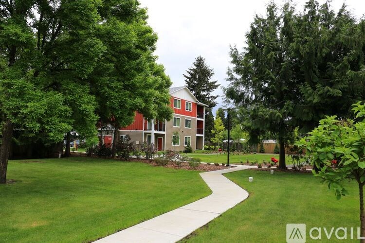 A red and white building is surrounded by trees and greenery.