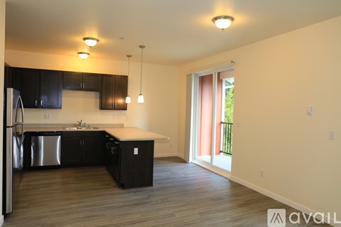 A kitchen with black cabinets and stainless steel appliances.