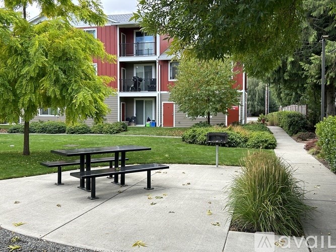 A picnic table is in front of a red building.