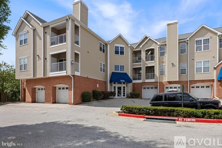 A large apartment complex with a parking lot in front.
