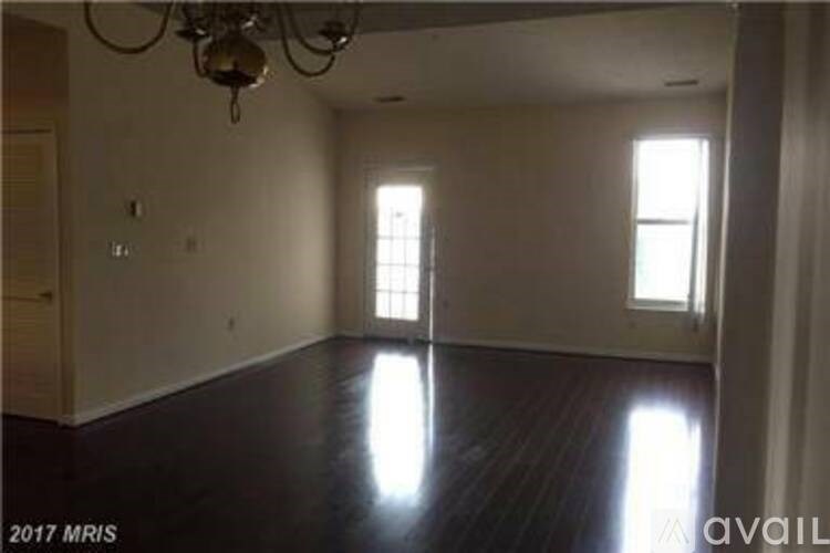 A room with a chandelier and two windows.