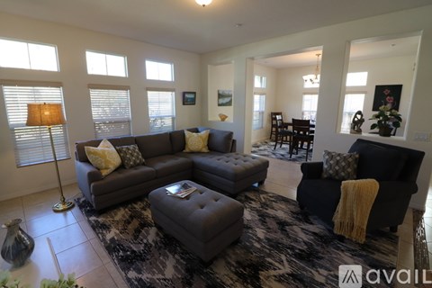 A living room with a grey couch and a black chair.