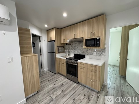 A kitchen with wooden cabinets and a stone backsplash.