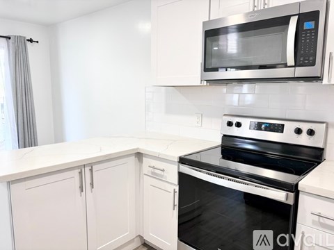 A modern kitchen with white cabinets and a stainless steel oven.