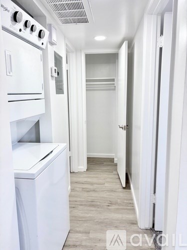 A white kitchen with a washing machine and a refrigerator.