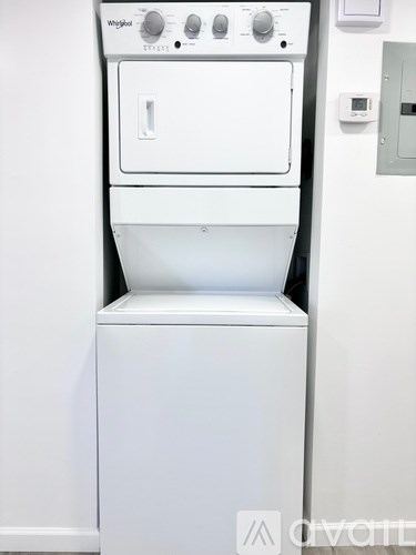 A white Whirlpool dryer and washer stacked on top of each other.