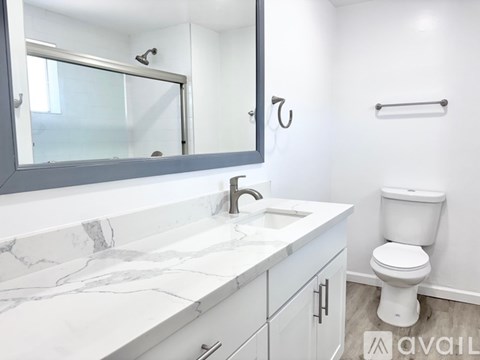 A bathroom with a marble countertop and white toilet.