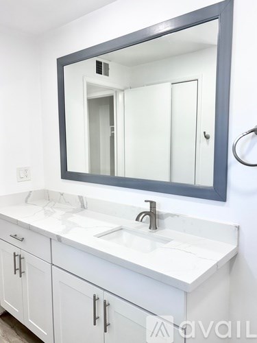 A bathroom vanity with a sink and mirror.