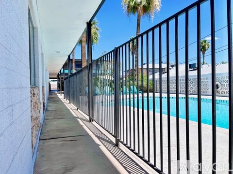 A black metal fence runs along the side of a pool.