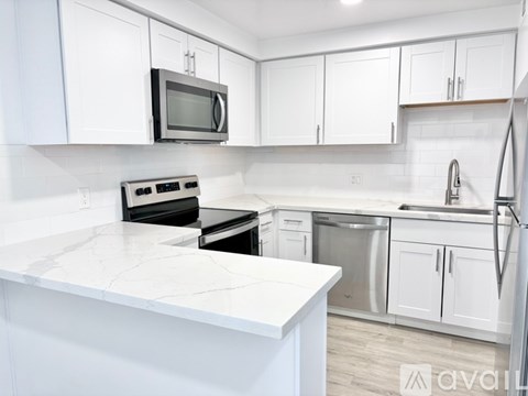 A kitchen with white cabinets and appliances.