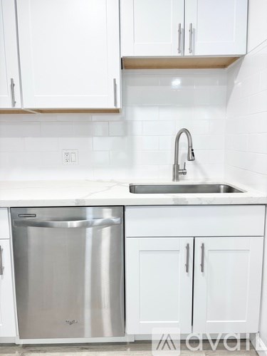 A kitchen with white cabinets and a stainless steel dishwasher.