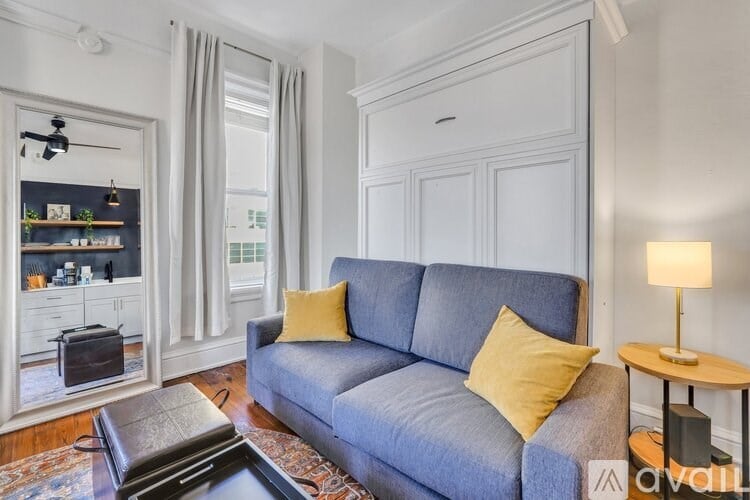 A living room with a grey sofa and a yellow pillow.