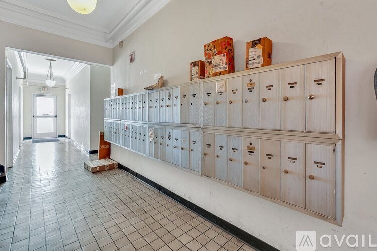 A long row of mailboxes are lined up on a wall.