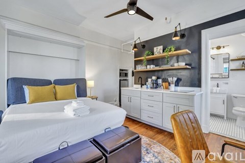 A bedroom with a large bed and a ceiling fan.