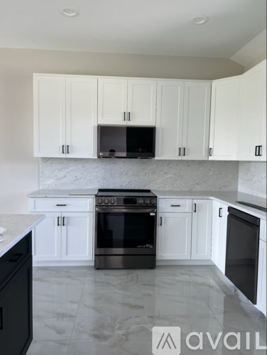 A kitchen with white cabinets and a black oven.