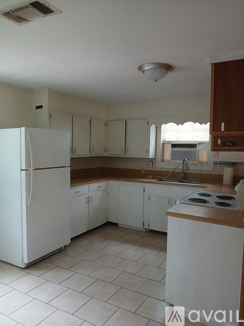 A kitchen with white appliances and cabinets.