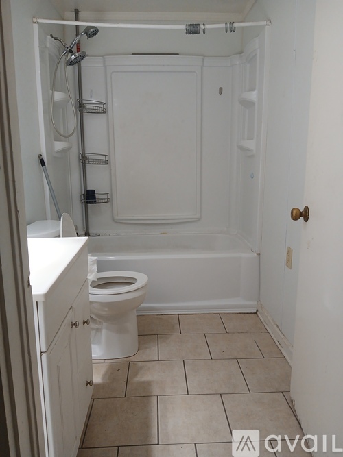 A white toilet in a small bathroom with a walk-in shower.