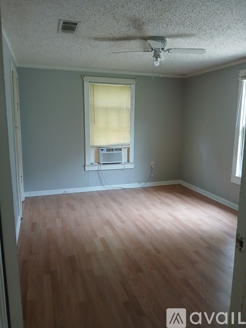 A room with wooden floors and a ceiling fan.