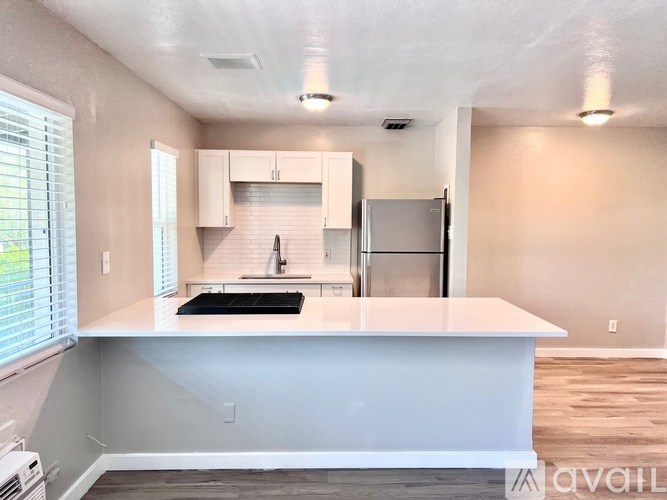 A kitchen with white countertops and stainless steel appliances.