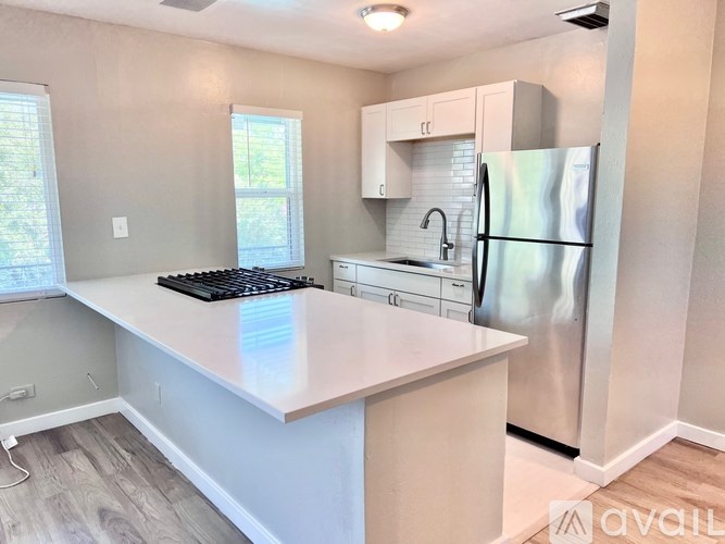 A kitchen with a white countertop and stainless steel appliances.