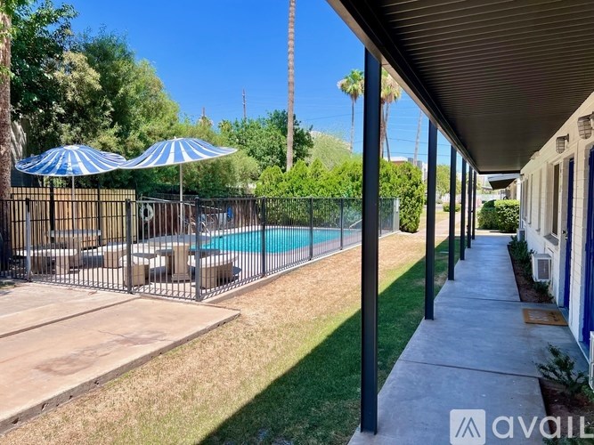 A pool area with a fence and umbrellas.