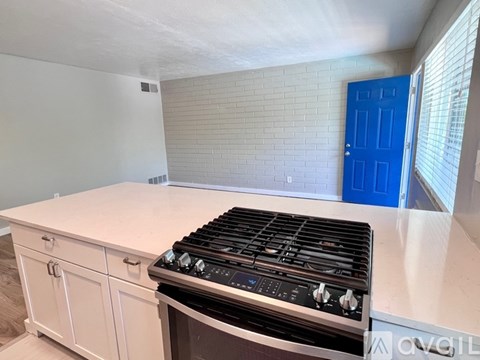 A kitchen with a white countertop and a black stove top oven.