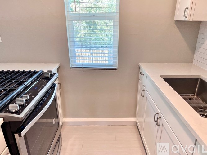 A kitchen with a stove and a window.