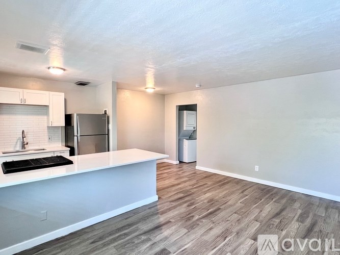 A kitchen with white countertops and a refrigerator.