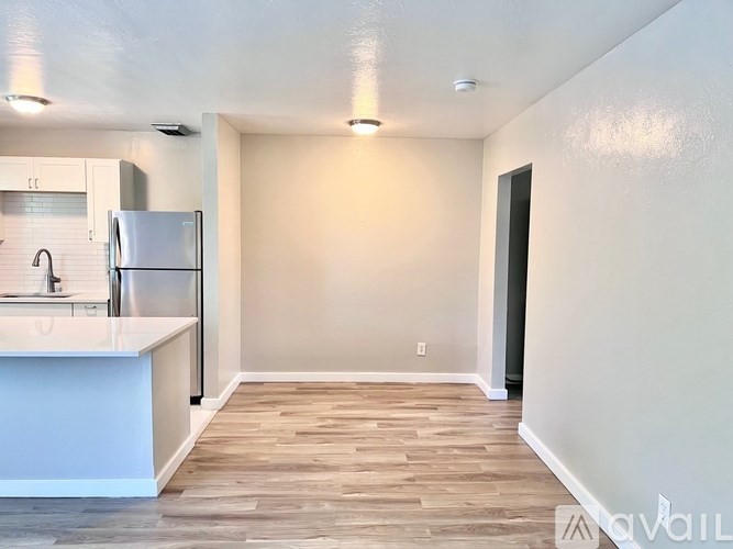 A kitchen with a refrigerator, sink, and countertop.