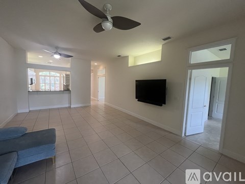 A living room with a blue couch and a flat screen TV mounted on the wall.