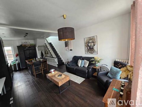 A living room with a black couch and a wooden coffee table.