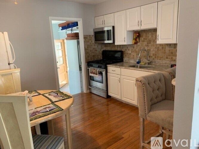 A kitchen with a table and chairs.
