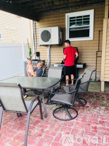 A man in a red shirt is standing at a table with a woman and a child.