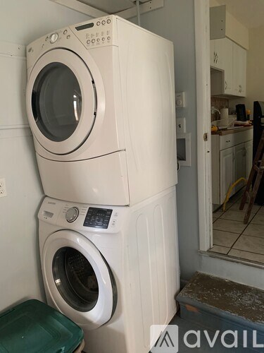 A stack of two washing machines in a laundry room.