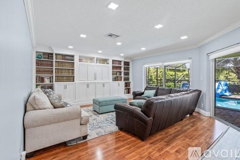 A living room with a couch, a chair, and a bookshelf filled with books.