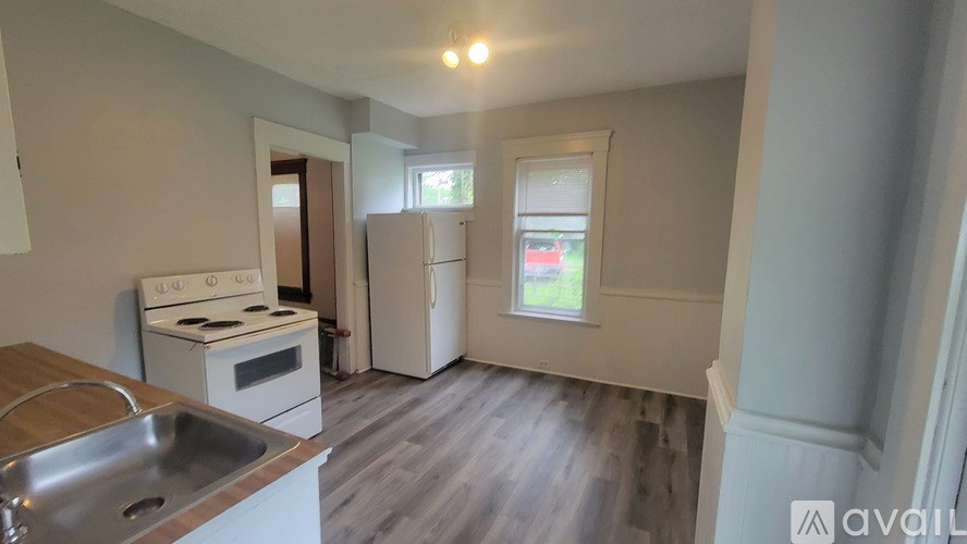 A kitchen with a stove, sink, and refrigerator.