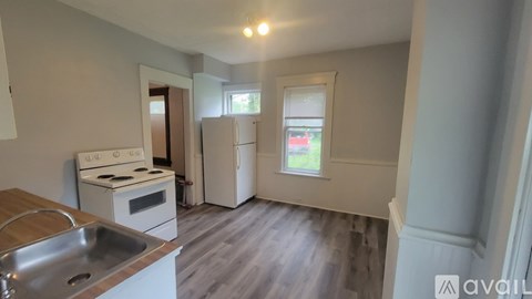 A kitchen with a stove, sink, and refrigerator.