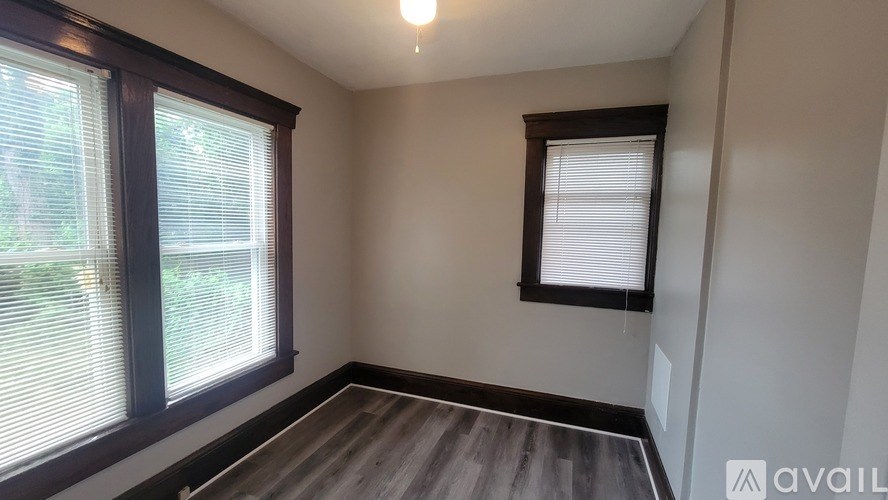 A room with a window and wooden flooring is available for rent.