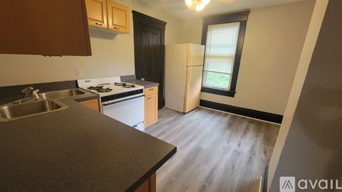 A kitchen with a sink, stove, and refrigerator.